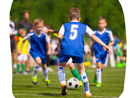 Young academy players playing a soccer game.